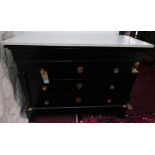 An early 20th century French ebonised commode with a white marble top over four long drawers with