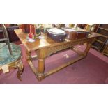 A late 18th century oak refectory table, the plank top over later carved frieze and turned