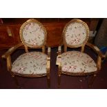 A pair of French Louis XV style carved giltwood fauteuils with floral upholstery over fluted