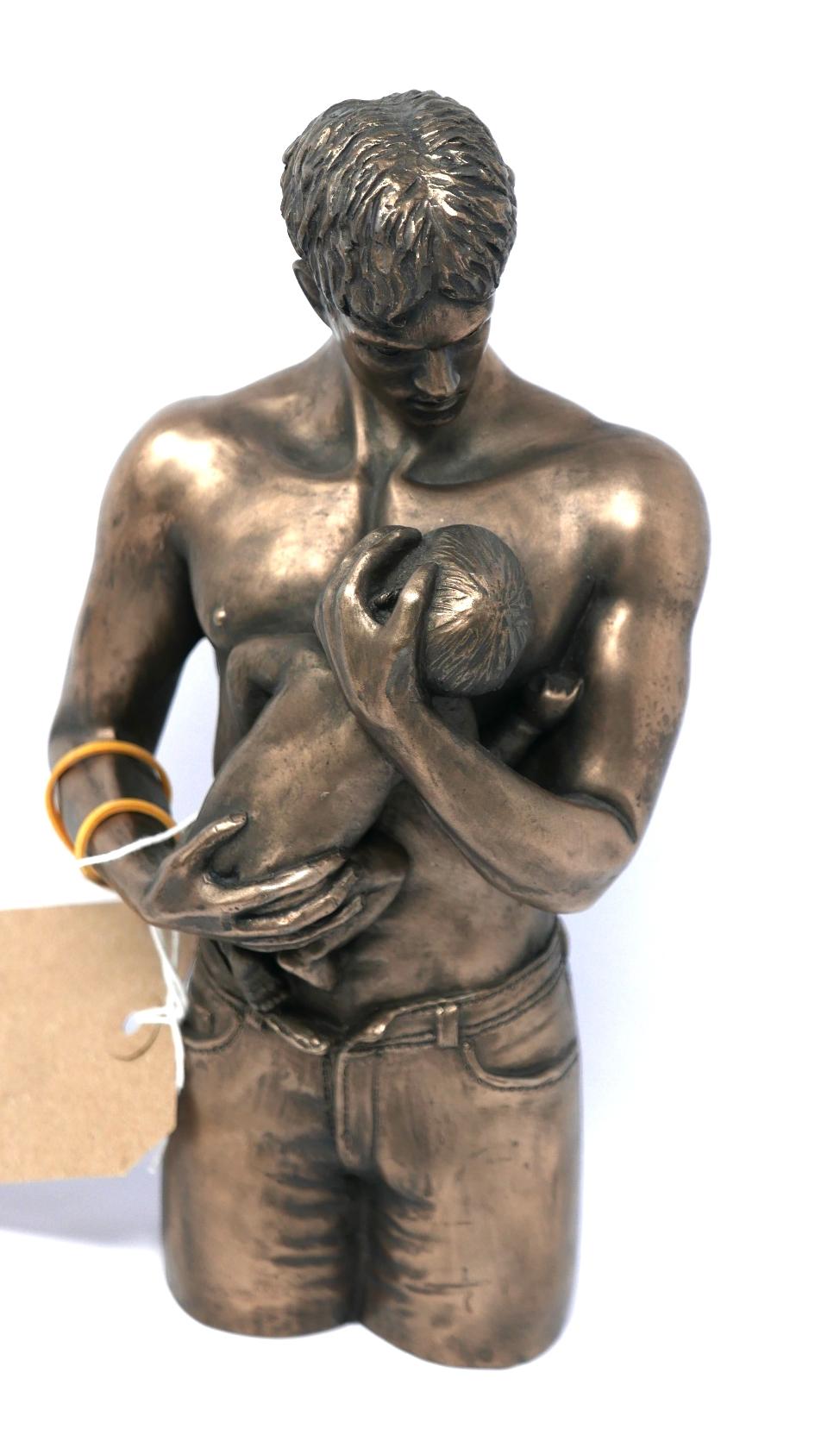 A Continental resin figural study of a father holding his child, H.26cm