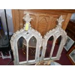 A pair of Gothic style carved wooden arched wall mirrors in a distressed finish, H.122cm W.60cm (2)