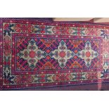 A small Afghan rug, the triple pole medallion on a scarlet ground within a stylised floral border,