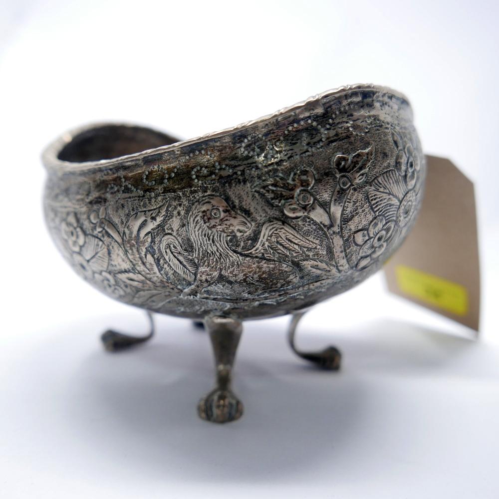 A white metal concave bowl, repousse decorated with griffins amongst flowers, on paw feet - Image 2 of 3