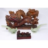 A pair of Chinese jade birds together with two wooden dragons and a resin fish ornament