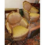 A pair of Louis XV style giltwood armchairs, with golden silk upholstery, raised on cabriole legs