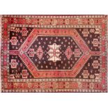 A North West Persian Zanjan rug, central diamond medallion on a rouge field within geometric border,