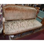 An early 20th century French walnut sofa, parcel gilt, with floral damask upholstery, raised on