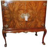 An early 20th century mahogany and burr walnut cocktail cabinet, with parcel gilding, the two