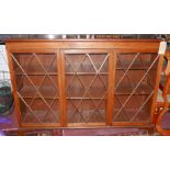 An early 20th Century mahogany triple bookcase, with astragal glazed doors enclosing shelves