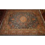 A signed Tabriz design rug, the central foliate medallion on a midnight blue ground with vines and