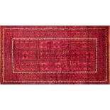 A North East Persian Turkoman rug, repeating stylised geometric motifs on a rouge field complimented