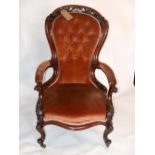 A Victorian carved mahogany spoon back armchair, with pink button back velour upholstery, raised