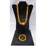 An antique Chinese amber bead necklace composed of twenty-seven polished graduated beads, 98g, L: