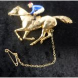 A boxed 9ct yellow gold and enamelled horse and jockey brooch with 9ct yellow gold safety chain, 9.