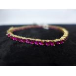 An 18ct yellow gold natural ruby tennis bracelet, claw-set with fifty-two marquise-shaped faceted