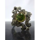 A Belle Epoque yellow gold, diamond and peridot ring, the central round bezel-set peridot framed