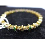 An 18ct yellow gold diamond and emerald bracelet, composed of alternating double emeralds and