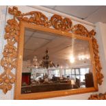 A carved black forest mirror, parcel gilt, with floral border, 100 x 143cm