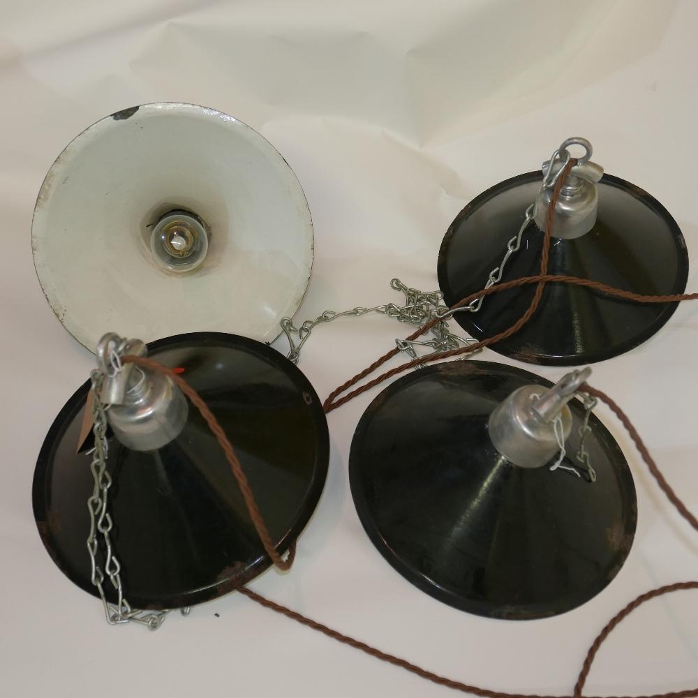 A set of four industrial enamelled ceiling light pendants