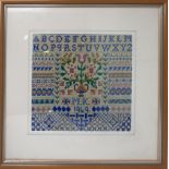 A mid 20th century woollen sampler dated 1949, framed and glazed, in shades of blues, greens and