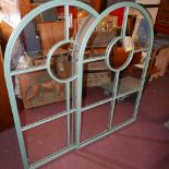 A pair of large arched garden mirrors with green painted metal frames, H.122cm W.79cm (2)