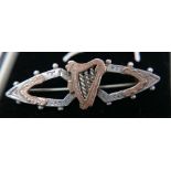 An antique sterling silver and rose gold sweetheart brooch centrally set with a rose gold Celtic