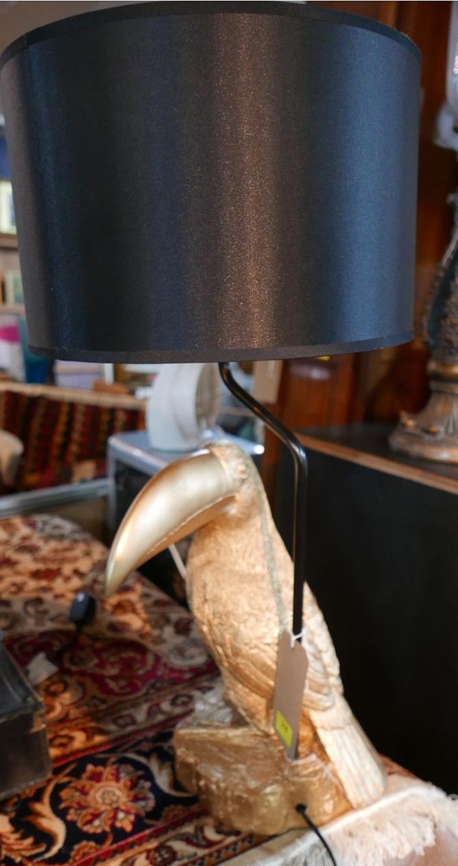 A contemporary table lamp, with a gilt a gilt composite toucan base and black drum shade, H.71cm