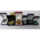 A collection of six boxed vintage costume jewellery brooches inset with crystals in shades of