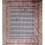 A Bokhara style carpet with elephant pad motifs on a blue ground, contained by geometric borders,