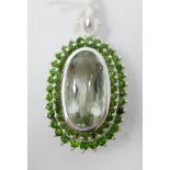 A large sterling silver oval-shaped, green amethyst and green diopside studded pendant with sterling