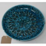 A Middle Eastern blue glazed pottery dish, decorated with stylised flowers to center within
