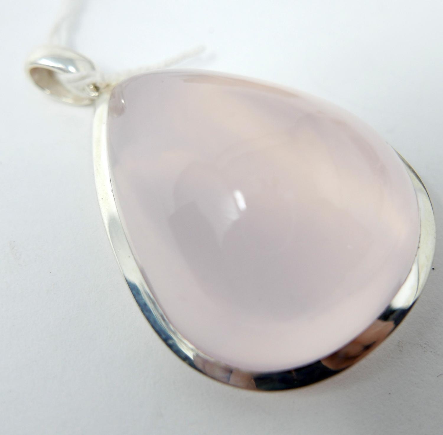 A sterling silver pendant inset with a large tear-drop shaped rose quartz cabochon to a sterling