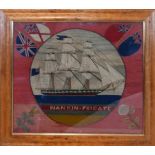 A Victorian needlework embroidery depicting the Nankin Frigate, flanked by flowers and flags, in