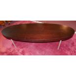 A contemporary low table, with a long stained teak oval top raised on slender aluminium supports,