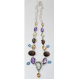 A sterling silver gem-set drop necklace set with faceted smokey quartz, green and purple