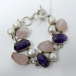 A chunky sterling silver bracelet set with faceted rose quartz and amethyst with six large