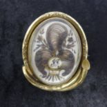 A Georgian rolled gold mourning brooch created with hair and set with three small pearls, 'J.J' in a