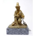 A cast gilt metal figure of a man playing the bagpipes, on rectangular marble base, H.27cm