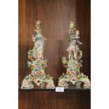 A PAIR OF DRESDEN STYLE STANDS decorated with a man and woman in typical floral dress