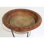 A LARGE RUSTIC WOODEN BOWL, constructed in sections with Brass Hoop Straps, on a Wrought Iron Stand