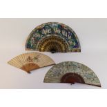 A 19TH CENTURY CHINESE PAINTED FAN DEPICTING COURTLY FIGURES, mounted on laquered sticks with gilt