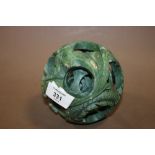 AN UNUSUAL CARVED GREEN SOAPSTONE PUZZLEBALL FEATURING DRAGONS