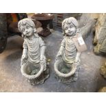 TWO SMALL GARDEN ORNAMENTS OF A GIRL HOLDING BASKET