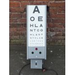 A VINTAGE WALL MOUNTED ROTATING OPTICIANS EYE SIGHT TESTING LIGHT, each panel with numerals and