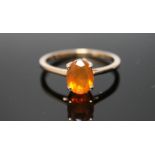 A HALLMARKED 9 CARAT YELLOW GOLD FIRE OPAL RING, with an oval claw set fire opal measuring approx