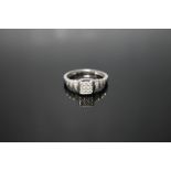 A 10K WHITE GOLD DIAMOND CLUSTER RING, having nine brilliant cut diamonds in a square setting and