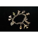 A 9 CARAT GOLD CHARM BRACELET, adorned with nine charms, approx weight 25.3g