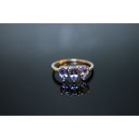 A HALLMARKED 9K GOLD TRIPLE PEAR SHAPED TANZANITE RING, coming with certificate stating stones are