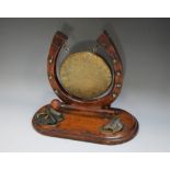 AN EQUESTRIAN THEMED HORSESHOE TABLE GONG, the gilt circular gong mounted on carved horseshoe,