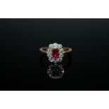 AN 18 CARAT RUBY AND DIAMOND RING, set with an oval ruby of approx 0.75 carat and surrounded by